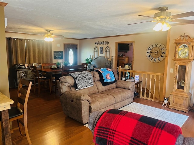 living room with hardwood / wood-style flooring, ceiling fan, crown molding, and a textured ceiling