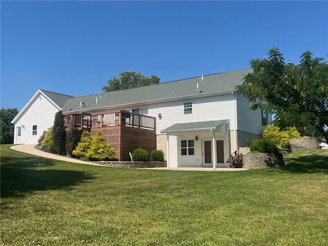 rear view of property featuring a lawn and a wooden deck