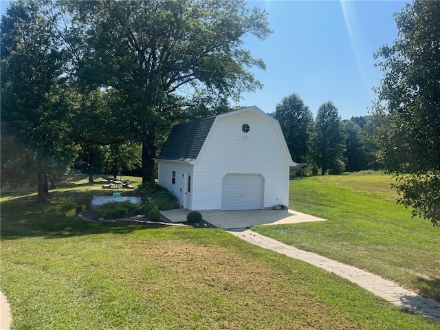 view of outdoor structure with a lawn and a garage