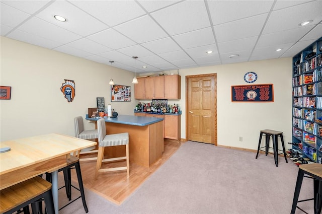 2 Rosewood Ct, Paris, IL 61944 - kitchen featuring light colored carpet, kitchen peninsula, a breakfast bar area, and hanging light fixtures