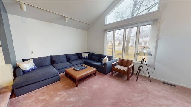 living area with carpet flooring, a healthy amount of sunlight, visible vents, and track lighting