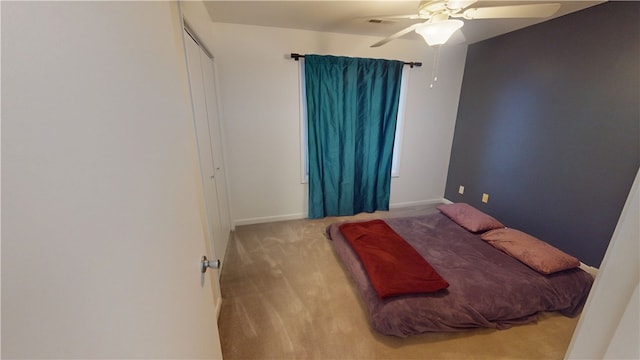 carpeted bedroom with baseboards, visible vents, and a ceiling fan