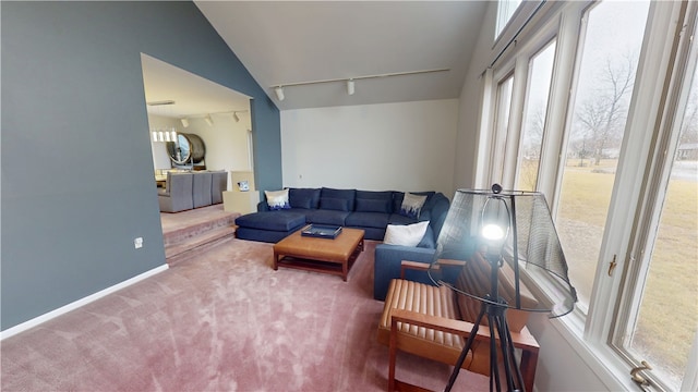 carpeted living room featuring baseboards, vaulted ceiling, and track lighting