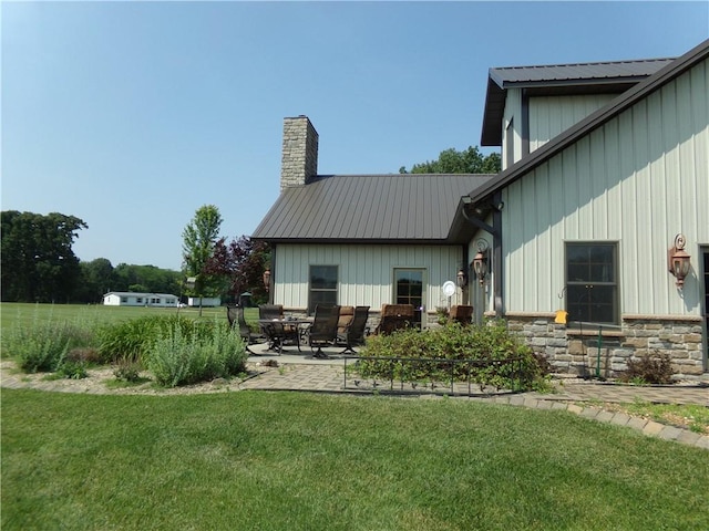 2277 County Highway 3, Findlay, IL 62534 - rear view of property with a yard, board and batten siding, stone siding, a patio, and a chimney