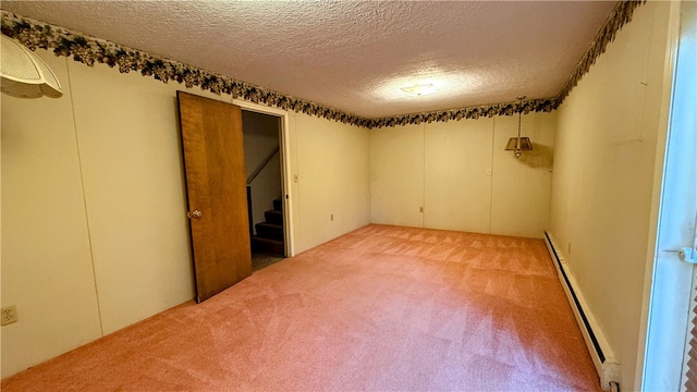 unfurnished room featuring a textured ceiling, a baseboard radiator, and carpet floors