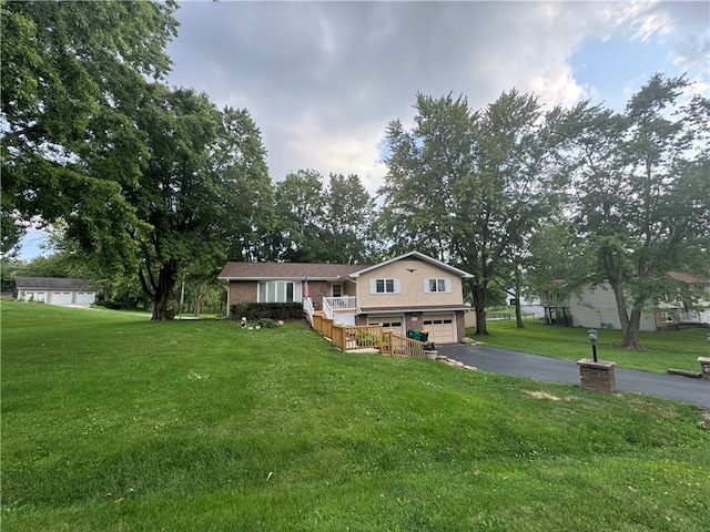 split level home with a garage and a front lawn