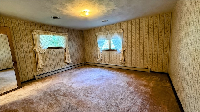 carpeted empty room featuring a baseboard radiator and plenty of natural light