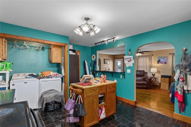 interior space with laundry area, arched walkways, a notable chandelier, baseboards, and washer and clothes dryer