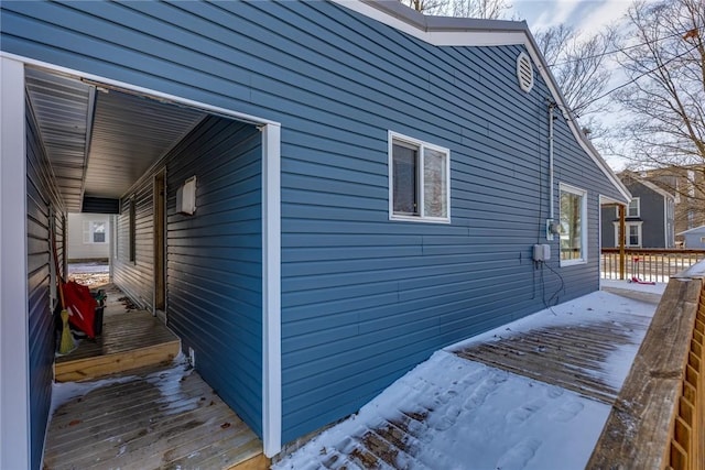 view of snowy exterior with a wooden deck