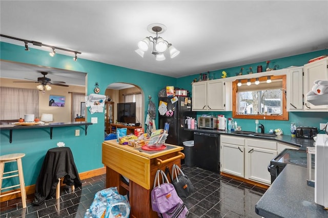 kitchen featuring a sink, black appliances, dark countertops, and white cabinetry