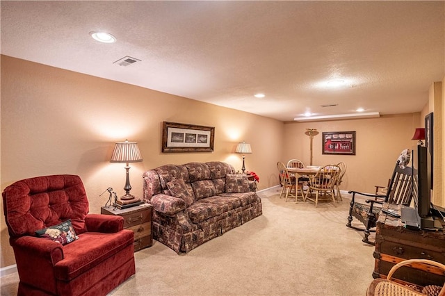 living room featuring visible vents, light carpet, a textured ceiling, recessed lighting, and baseboards