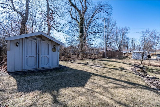 view of yard featuring a shed, an outdoor structure, and fence