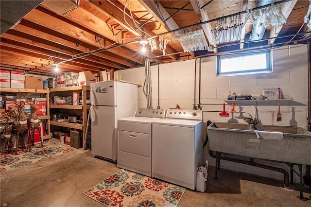 basement featuring washing machine and dryer and freestanding refrigerator