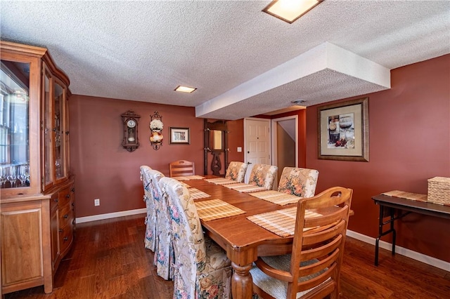 dining room with dark wood finished floors, baseboards, and a textured ceiling