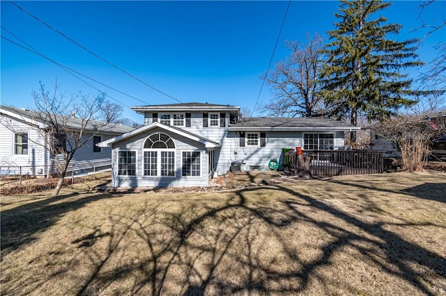 back of property featuring a wooden deck, a yard, and fence