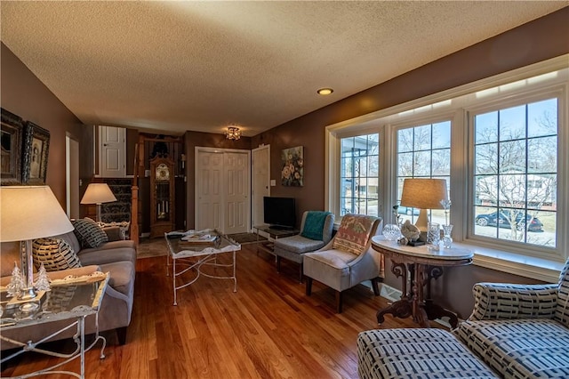 living area with a textured ceiling and wood finished floors