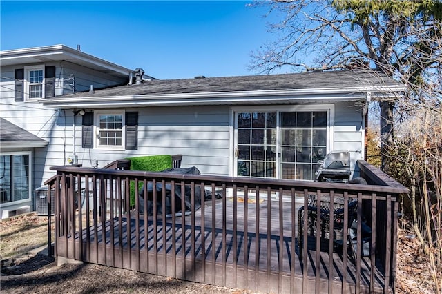 exterior space featuring roof with shingles and a wooden deck