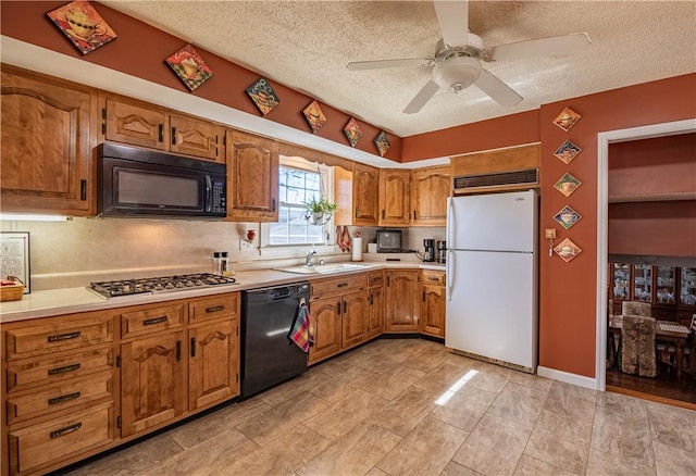 kitchen with black appliances, light countertops, brown cabinetry, a textured ceiling, and a sink