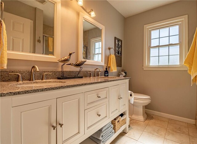 bathroom featuring a sink, an enclosed shower, baseboards, and toilet