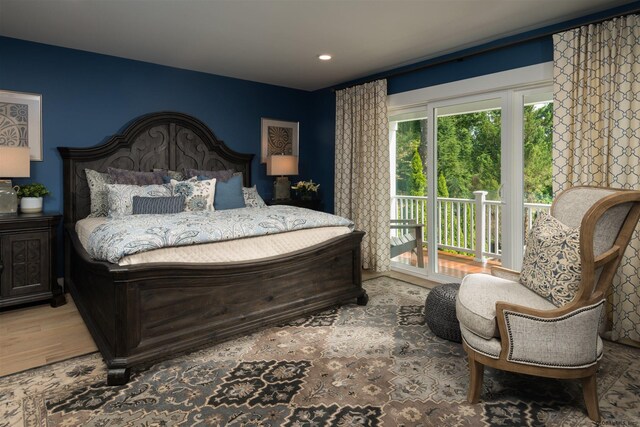 bedroom featuring multiple windows, access to outside, and wood-type flooring