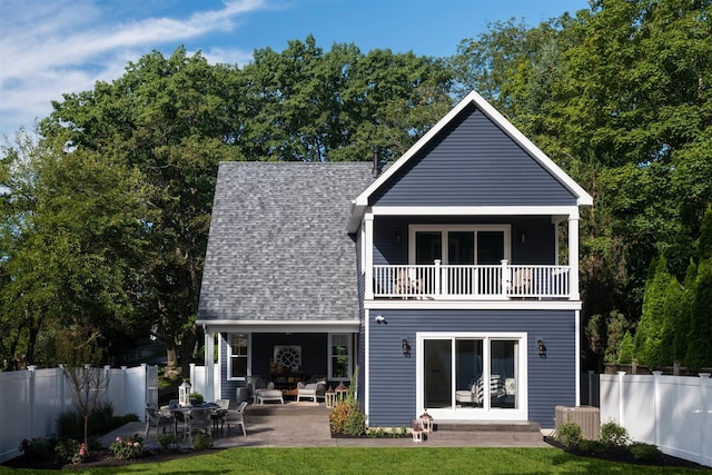 back of house featuring a balcony, central AC, a lawn, and a patio