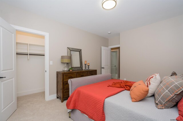 carpeted bedroom with a closet and a spacious closet