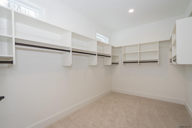 walk in closet featuring light colored carpet