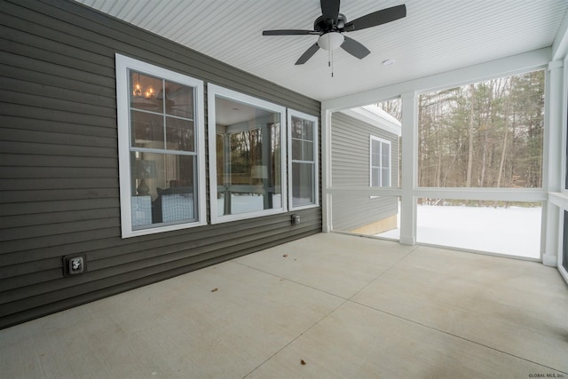 unfurnished sunroom featuring ceiling fan and plenty of natural light