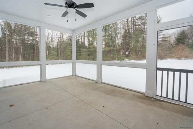 unfurnished sunroom with ceiling fan