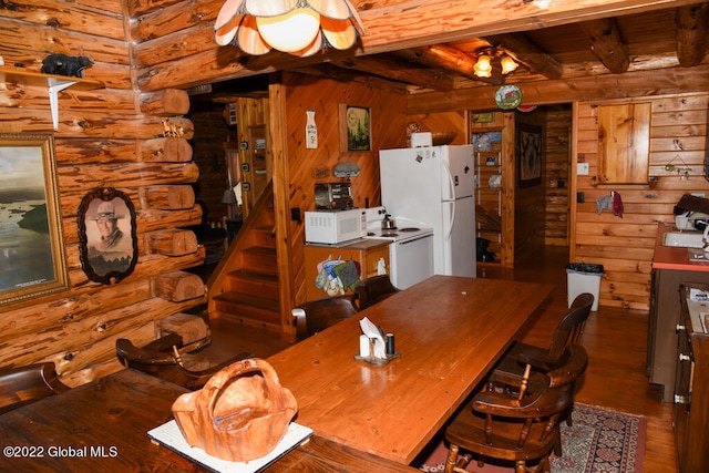 dining room with dark hardwood / wood-style flooring, wooden walls, rustic walls, and beamed ceiling