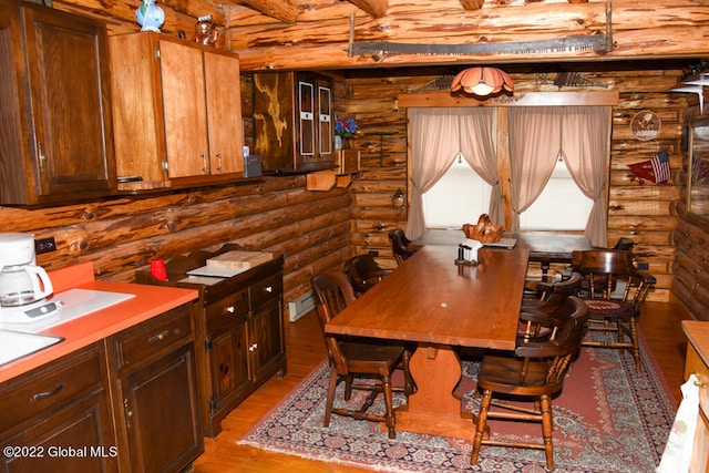 dining space featuring log walls and light wood-type flooring