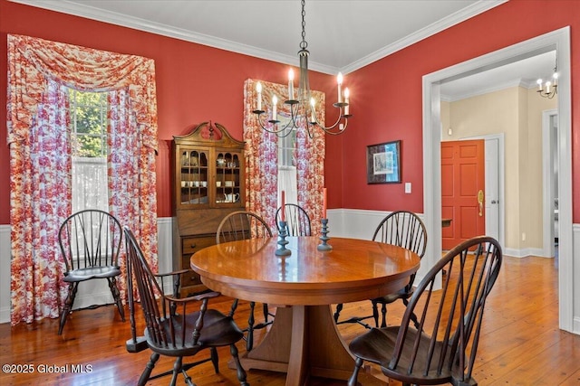 dining space featuring a notable chandelier, crown molding, and wood-type flooring