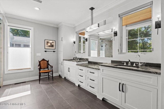 bathroom featuring a stall shower, double vanity, crown molding, and a sink