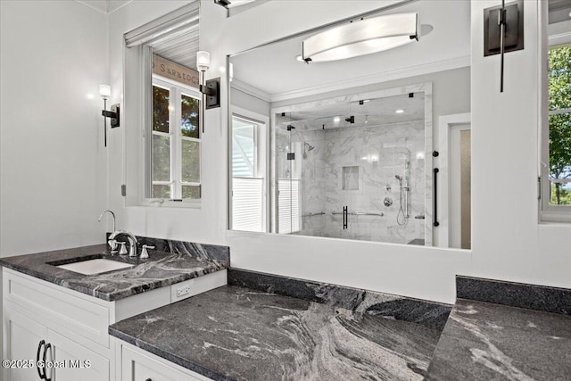 bathroom featuring plenty of natural light, ornamental molding, and a marble finish shower
