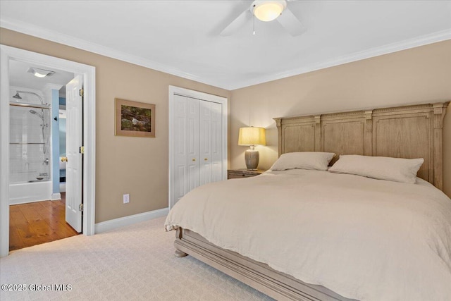 bedroom featuring a closet, crown molding, baseboards, and light colored carpet