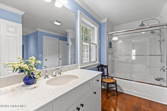 bathroom with vanity, shower / bath combination with glass door, crown molding, and wood finished floors
