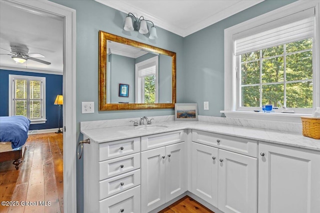 bathroom with ornamental molding, hardwood / wood-style flooring, ceiling fan, and a wealth of natural light