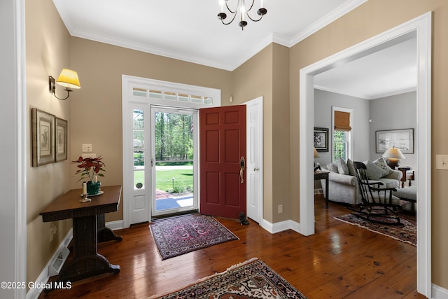 entrance foyer with baseboards, crown molding, hardwood / wood-style flooring, and a chandelier