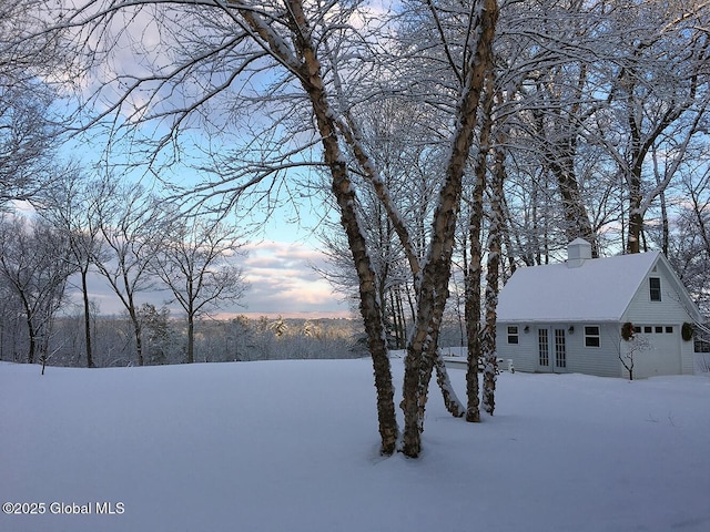 snowy yard with a garage
