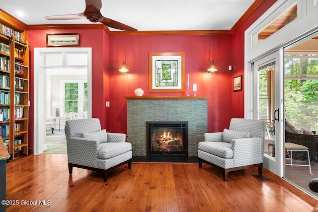 5 Winding Brook Dr, Saratoga Springs, NY 12866 - living area with a ceiling fan, healthy amount of natural light, ornamental molding, a stone fireplace, and wood-type flooring