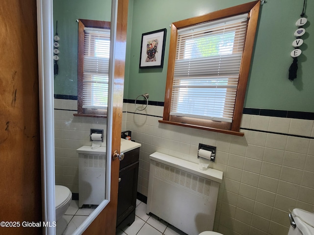 269 Broadway, Menands, NY 12204 - bathroom with radiator heating unit, toilet, tile walls, healthy amount of natural light, and wainscoting
