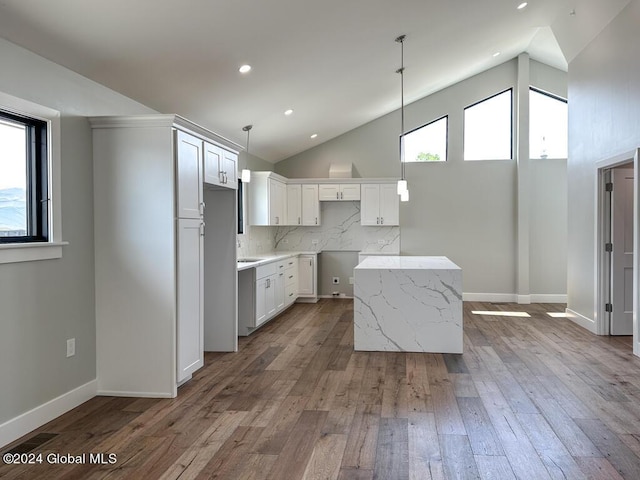 kitchen featuring a kitchen island, white cabinetry, backsplash, and a wealth of natural light