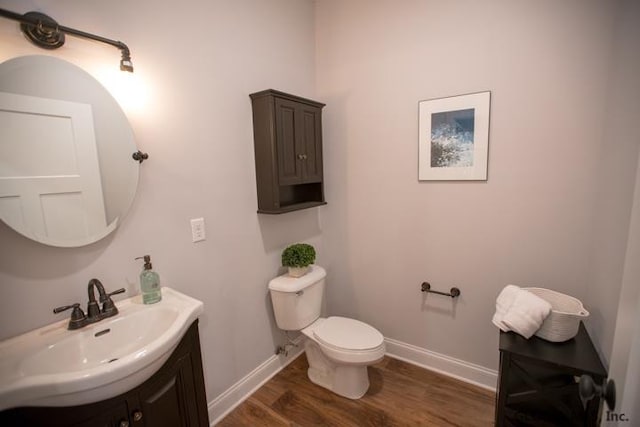 bathroom featuring vanity, toilet, and hardwood / wood-style flooring