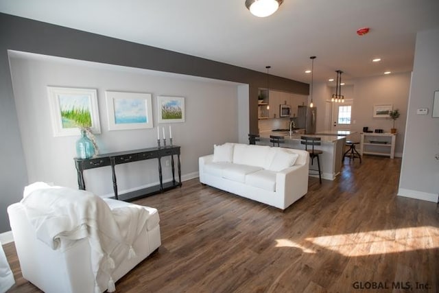 living room featuring a notable chandelier, dark wood-type flooring, and a wealth of natural light