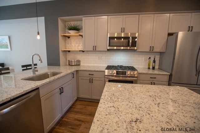 kitchen featuring dark hardwood / wood-style flooring, light stone countertops, stainless steel appliances, and hanging light fixtures