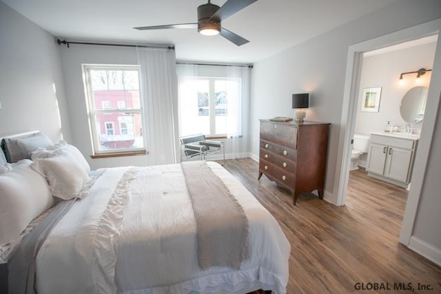 bedroom featuring connected bathroom, ceiling fan, and hardwood / wood-style flooring