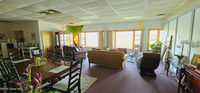 dining area with a paneled ceiling and carpet floors