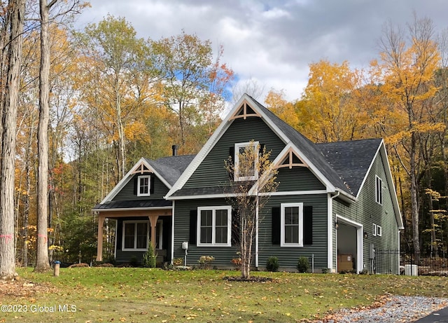 craftsman-style house featuring a porch, central AC unit, and a front lawn