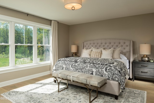 bedroom featuring multiple windows and light hardwood / wood-style flooring