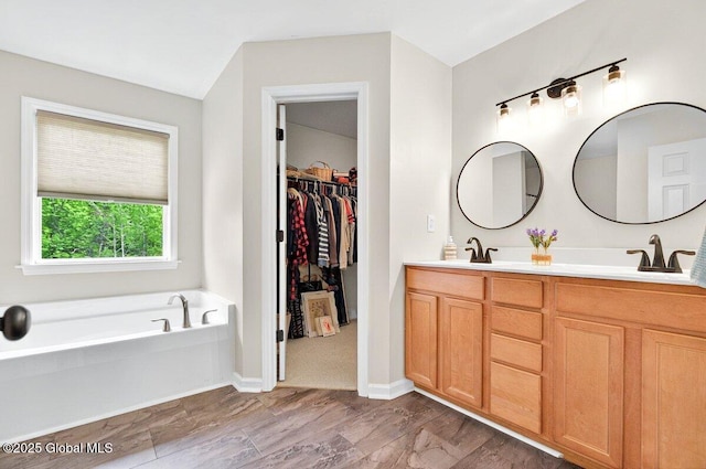 33 Sherman Way, Ballston Spa, NY 12020 - full bath featuring double vanity, a bath, a walk in closet, and baseboards
